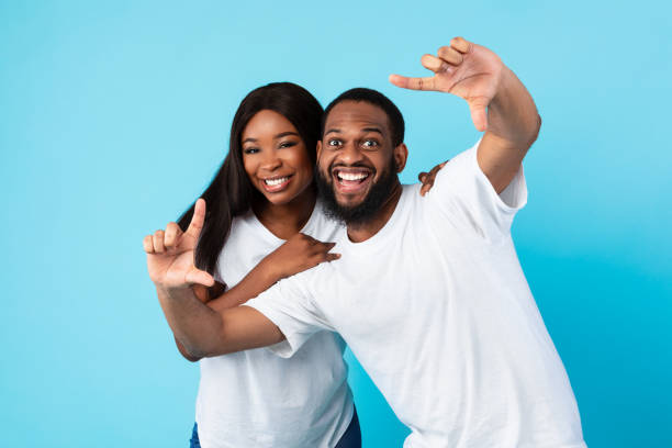 Black couple making picture frame with fingers