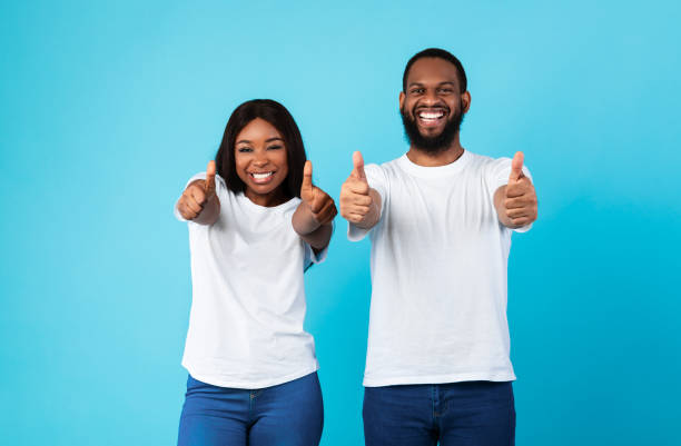 istock Happy black couple gesturing thumbs up and smiling 1309256925