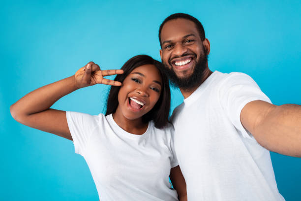 istock Black couple taking selfie showing victory sign or peace gesture 1309257773