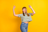 Portrait of charming carefree cheerful girl having fun dancing clubbing isolated over bright yellow color background