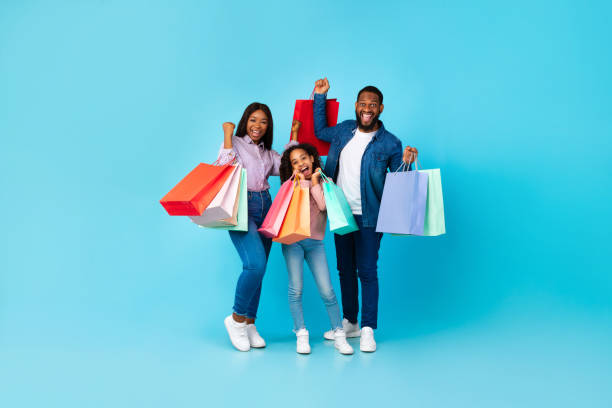 afro-americanos alegres segurando sacolas de compras com roupas novas - child excitement awe fun - fotografias e filmes do acervo