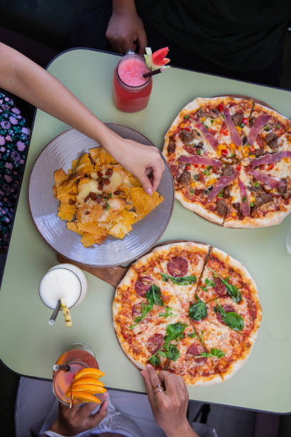 istock Top view of hands taking pizza and snacks from table in restaurant or cafe. Celebration, party or event concept. 1309260752