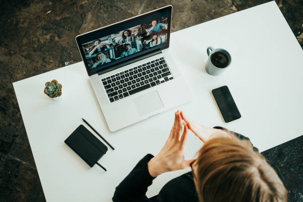 istock Woman has video conference with her remote team using laptop. Top view 1309260767
