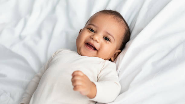 istock Cute little African American infant lying in bed 1309260904