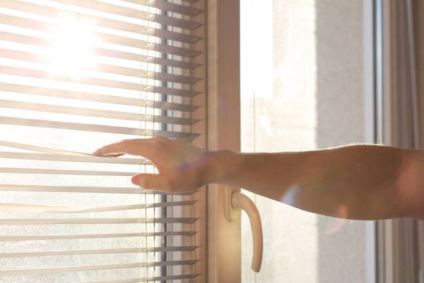 istock Male hand opening window blinds in sunny morning. Empty space 1309261123