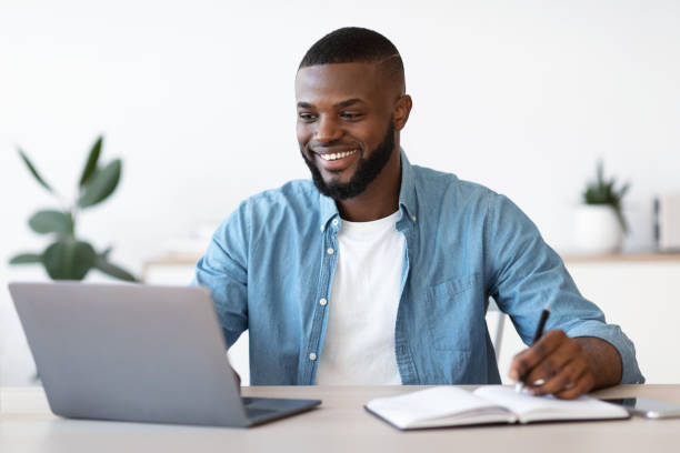 istock Black entrepreneur working at home office, typing on laptop and taking notes 1309261231