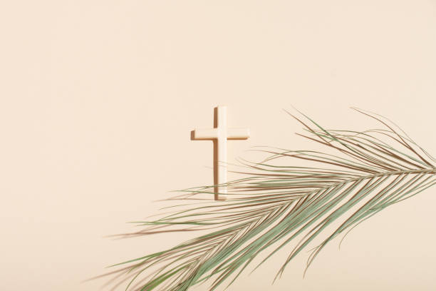 istock Palm Sunday and Easter concept. Cross or crucifix and palm leaf on light beige background. 1309261445
