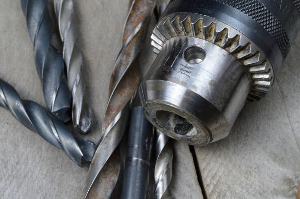 istock replaceable drill chuck and old drill bits lie on a wooden plank background. close-up. 1309261684