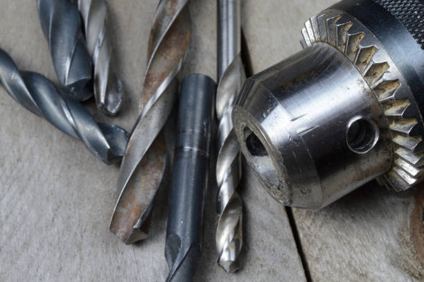 istock replaceable drill chuck and old drill bits lie on a wooden plank background. close-up. 1309261694