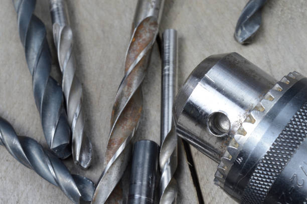 istock replaceable drill chuck and old drill bits lie on a wooden plank background. close-up. 1309261701