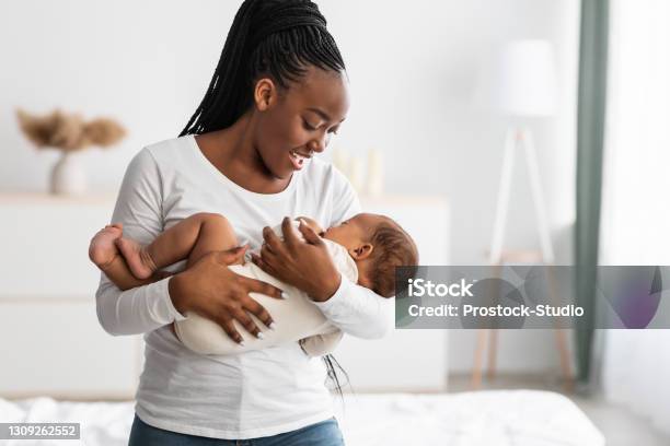 African American Mother Singing Lullaby For Infant To Sleep Stock Photo - Download Image Now