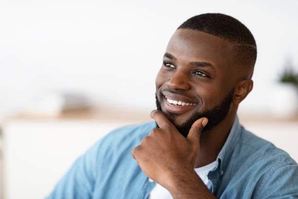 istock Portrait Of Handsome Smiling African American Man Touching Beard While Looking Away 1309263141