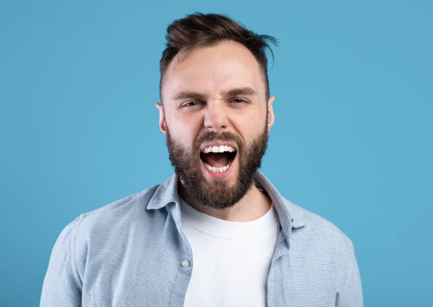 istock Enraged bearded guy shouting in anger, expressing his aggression over blue studio background 1309265339