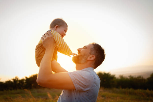 istock Father lifting his son in the air on a summer day 1309266083