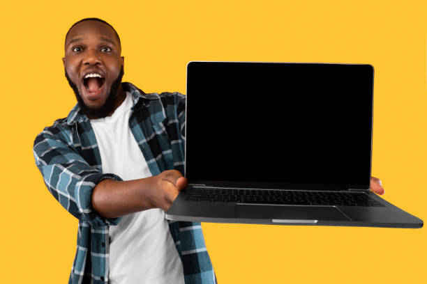 istock Black Guy Showing Big Laptop With Empty Screen, Studio Shot 1309266088