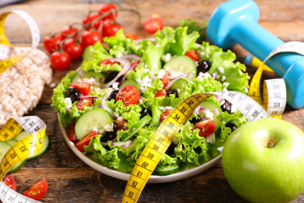 istock diet food concept with salad,  meter and dumbbell 1309266321