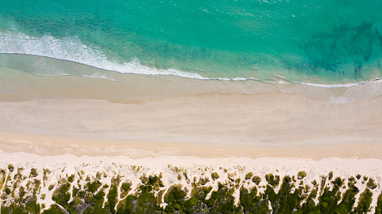 High angle shot of waves crashing onto the seashore