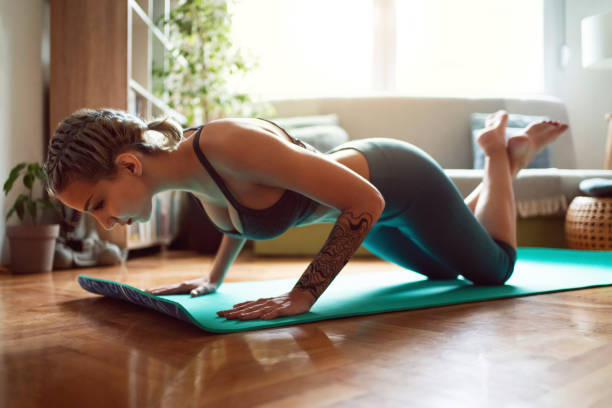 istock Young woman doing 
push-ups at home 1309266439
