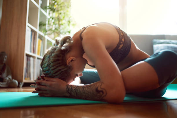istock Young woman in sportswear practicing on her mat, doing hip opening exercises 1309266451