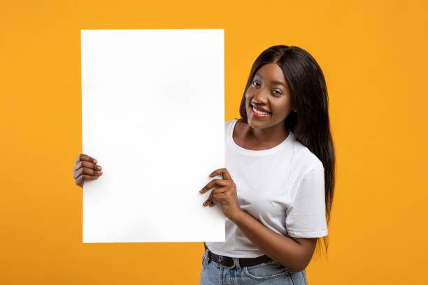 istock Pretty black woman holding blank board for advertisement 1309266514