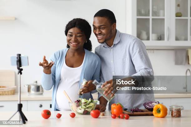 Happy Black Expecting Family Broadcasting While Cooking Stock Photo - Download Image Now