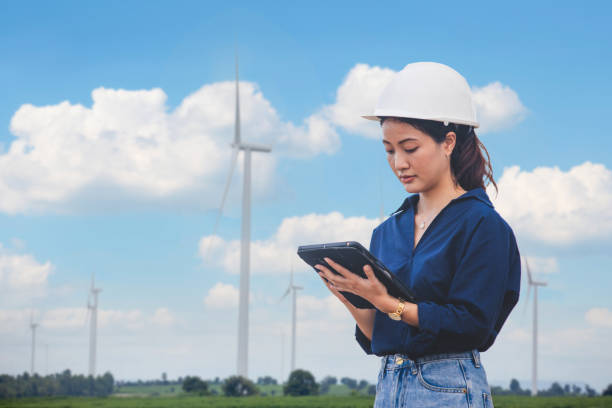istock Women engineer using tablet for working on site at wind turbine farm 1309266714