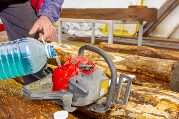 carpenter verse de l’essence d’une bouteille en plastique dans une tronçonneuse - gas fitter photos photos et images de collection