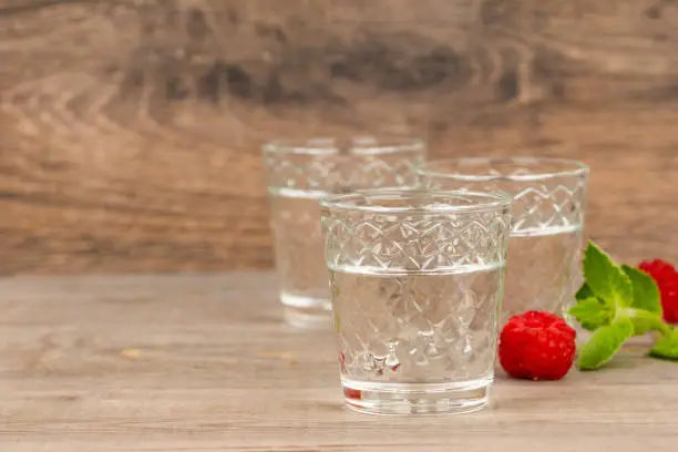 fruit alcoholic drink in shot glass on aged wooden table