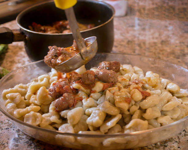 istock spoon dumping hot tomato sauce over a platter of gnocchi 1309274068