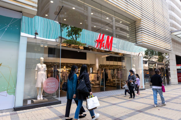 H&M fashion store in Hong Kong Hong Kong - March 26, 2021 : People walk past the H&M fashion store in Tsim Sha Tsui, Hong Kong. It is a Swedish multinational clothing-retail company. h and m stock pictures, royalty-free photos & images