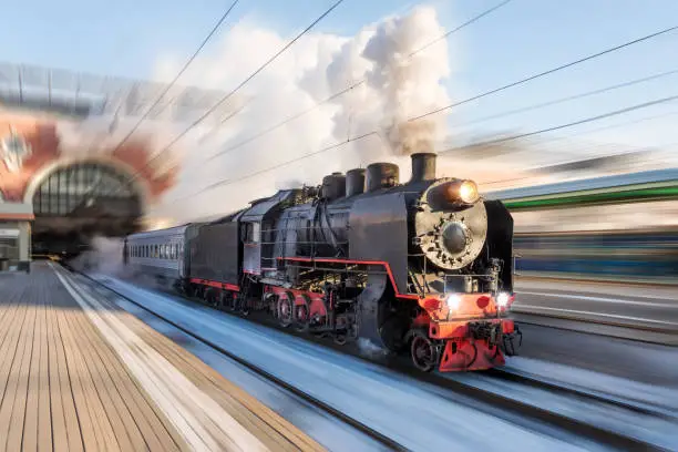 Photo of Locomotive steam with powerful clouds of smoke leaves the station for a retro trip motion speed.