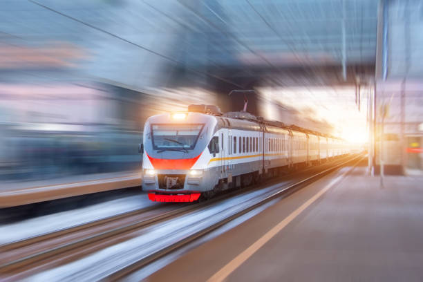 istock Speed suburban train with motion blur rides city station. 1309276796