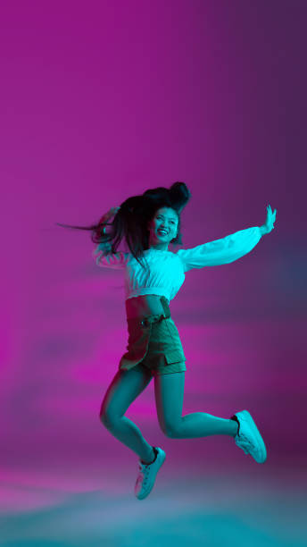 istock Young attractive Asian girl isolated on gradient background in neon light. 1309277572