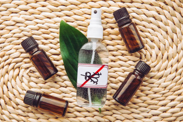 homemade essential oil based mosquito repellent. flat lay view of spray bottle surrounded by brown essential oil bottles on bamboo mat background. - insect repellant imagens e fotografias de stock