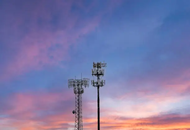 Photo of Two cellphone towers providing digital service to rural areas at sunset