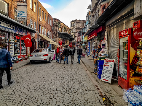 Istanbul, Turkey - October 29, 2019: People walking down the Kible Cesme Cd Street in Istanbul. Traditional old Turkish street in Sultanahmet area. Real life