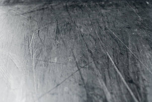 istock White scratches and dust on black plastic. Scratches on a snowboard close up. Paraffin application and ski equipment service. 1309284863