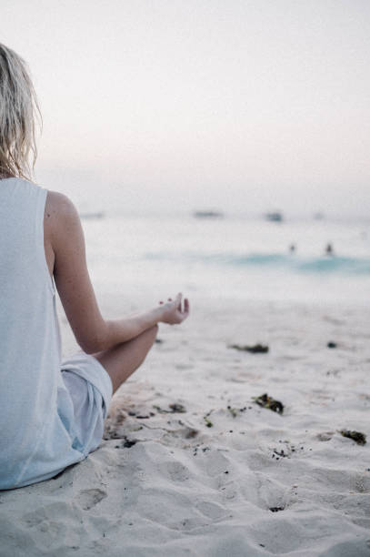 istock Meditating woman on the beach 1309286756
