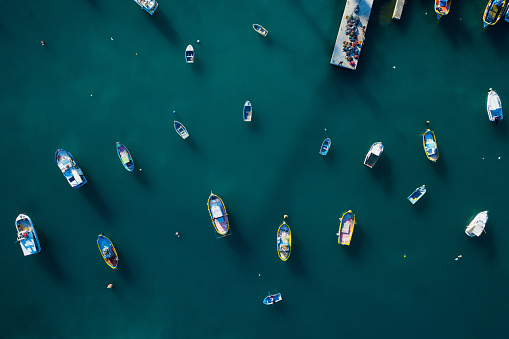 Aerial top view of fishing boats in the blue sea.