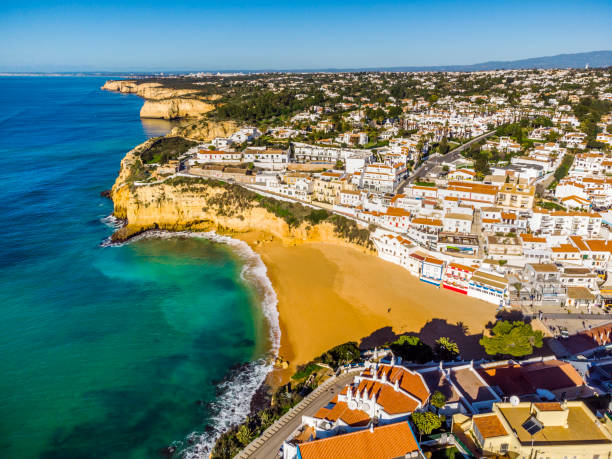 vista aerea di un'ampia spiaggia sabbiosa e architettura tradizionale di carvoeiro, algarve, portogallo - carvoeiro foto e immagini stock