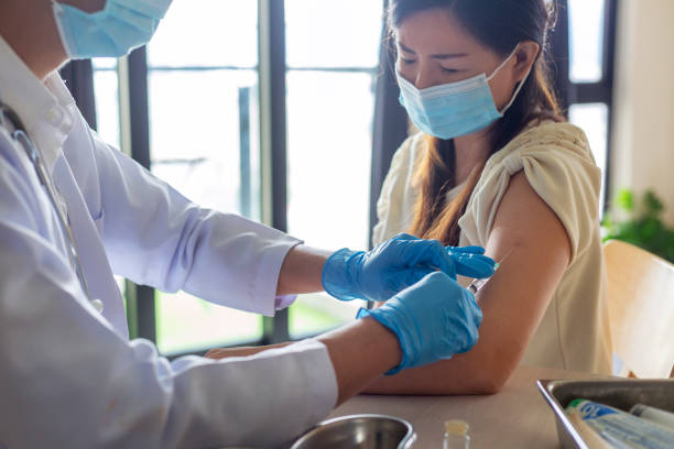 istock Woman with face mask getting vaccinated, coronavirus concept 1309291708