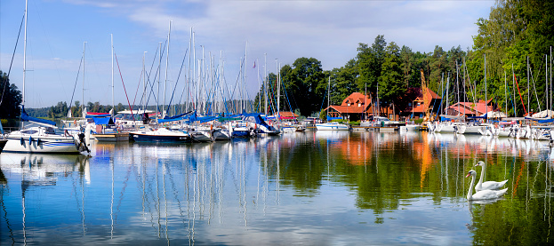 Waterfront with tour boats and yachts floating on Lake Geneva in Switzerland.