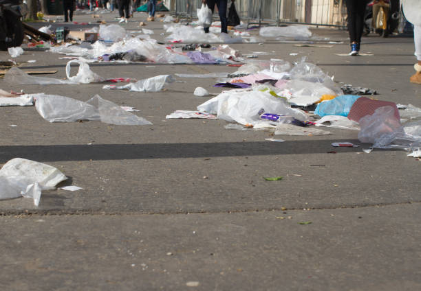 anonymous pedestrians walking through plastics and garbage polluting streets and flying through the pavements in Paris