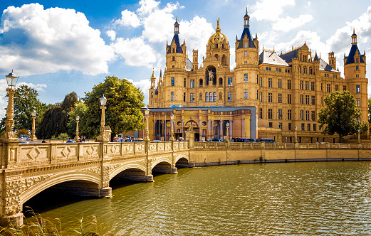 Main entrance of Schwerin Castle in Northern Germany. People are entering and leaving the castle over the bridge