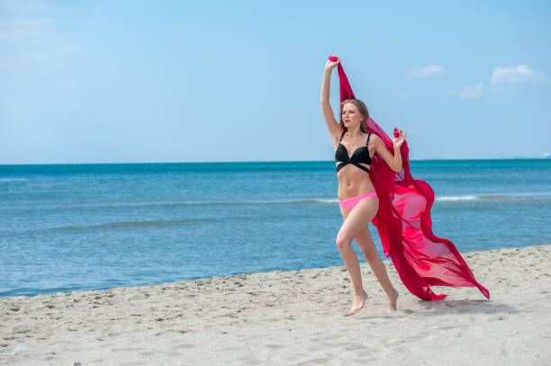 istock Young woman walking at the beach 1309299340