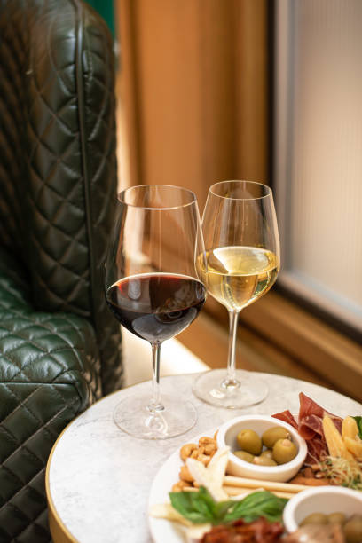 istock Assorted snacks. Cheese appetizer, cured meats, olives with two glasses of red and white wine in restaurant or cafe 1309300964