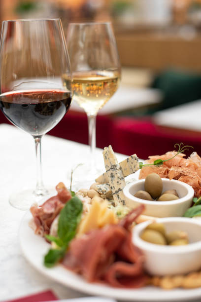 istock Assorted snacks. Cheese appetizer, cured meats, olives with two glasses of red and white wine in restaurant or cafe 1309300997