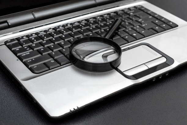 istock Magnifying glass on the laptop keyboard. 1309305557