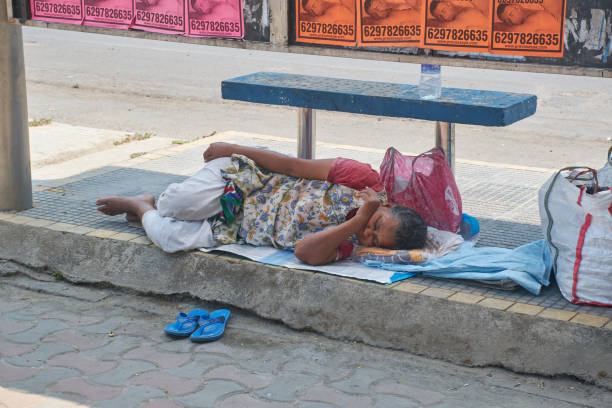 Kathmandu, Nepal - March 12, 2011: Leper covered with dirty clothes , sitting and begging on the street of Kathmandu near hindu temple Pashupati.