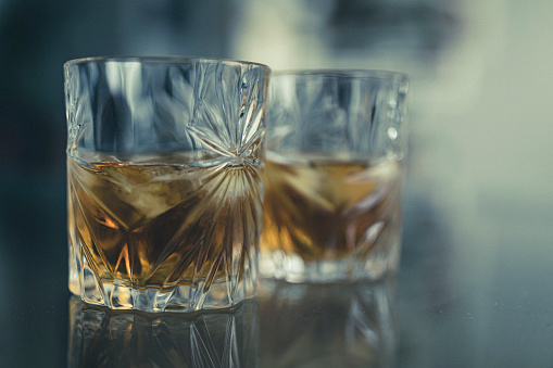 Glass of whisky, whisky tumbler,rocks glass or lowball on black mirror background.